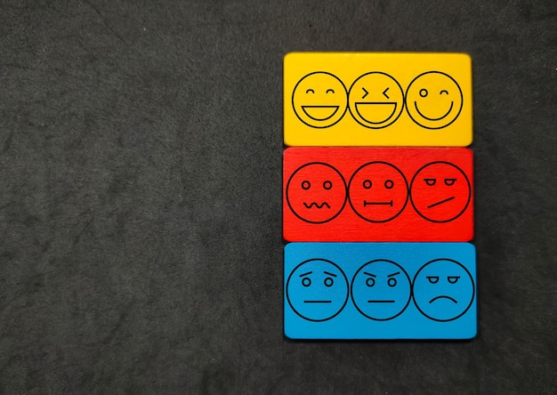 Coloridos bloques de madera con cara de emoción Concepto de evaluación y satisfacción del cliente