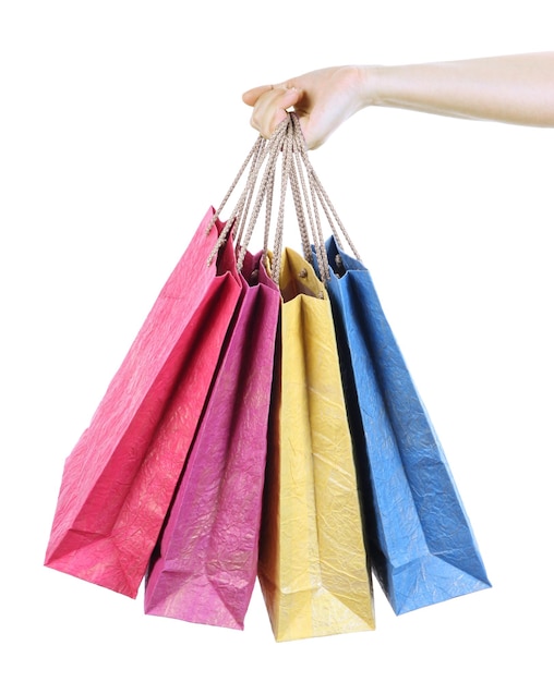 Coloridos bolsos de compras en mano femenina aislado en blanco