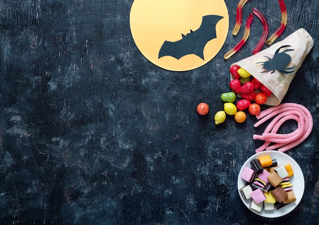 Coloridos caramelos masticables de regaliz de gelatina sobre un fondo negro Concepto de vacaciones de Halloween
