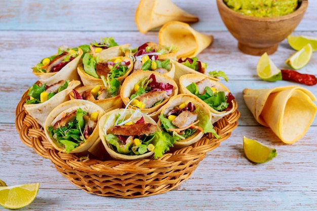 Coloridos conos de tortilla rellenos de fajita en cesta de mimbre