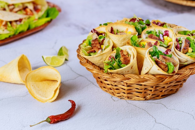 Coloridos conos de tortilla rellenos de fajita en cesta de mimbre