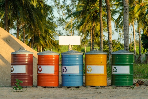 Coloridos contenedores de reciclaje en un paisaje tropical con cocoteros en el fondo Brasil