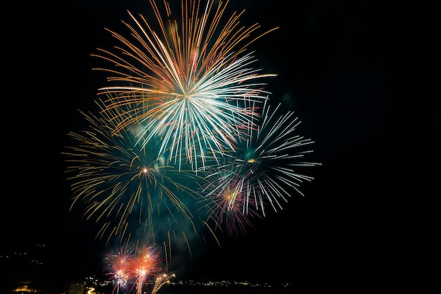 Coloridos fuegos artificiales sobre la ciudad por la noche geniales para fondos de pantalla