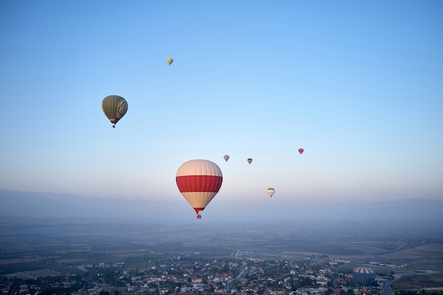 Coloridos globos aerostáticos volando en el cielo de la mañana