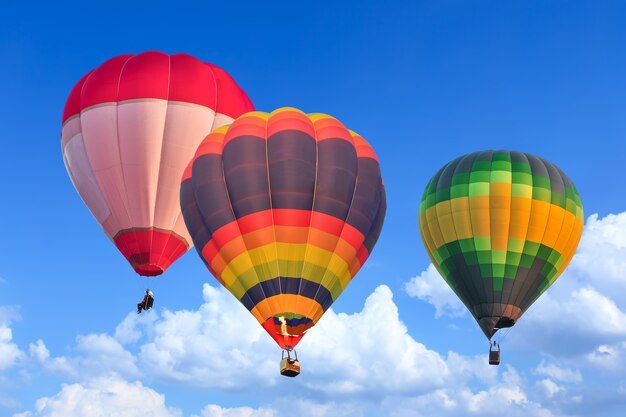 Coloridos globos aerostáticos en vuelo sobre el cielo azul
