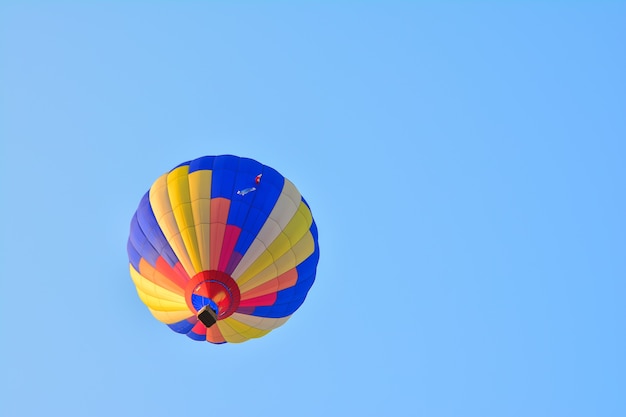 Coloridos globos aerostáticos en vuelo sobre el cielo azul