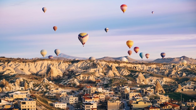 Coloridos globos de aire caliente sobrevolando la ciudad de Capadocia, Turquía. Montañas volcánicas en el parque nacional de Goreme por la mañana.