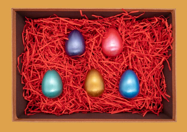 Coloridos huevos de Pascua en una caja en rojo