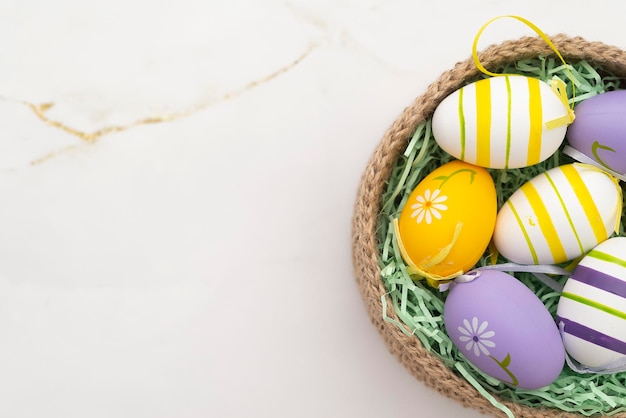 Coloridos huevos de Pascua en una canasta de punto sobre un fondo de mármol