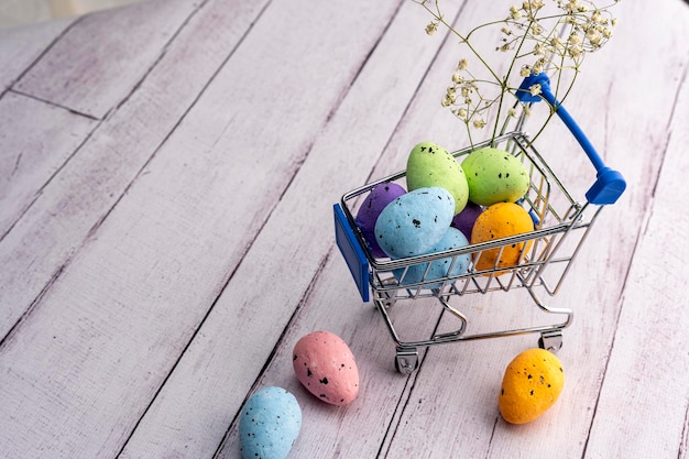 Coloridos huevos de Pascua en un carrito de supermercado Tarjeta de felicitación de Pascua