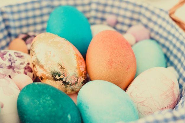 Coloridos huevos de Pascua en cesta de mimbre