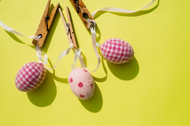 Coloridos huevos de Pascua con Cruz colgando en línea de pinzas para la ropa