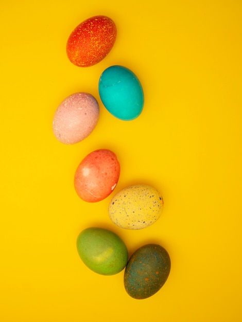 Coloridos huevos de Pascua en fondo amarillo