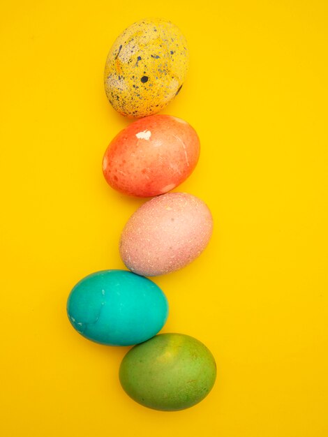 Coloridos huevos de Pascua en fondo amarillo