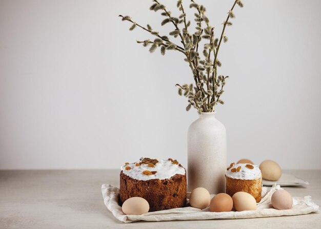 Coloridos huevos de Pascua y hornear con flores de primavera sobre fondo de madera Borde de vacaciones