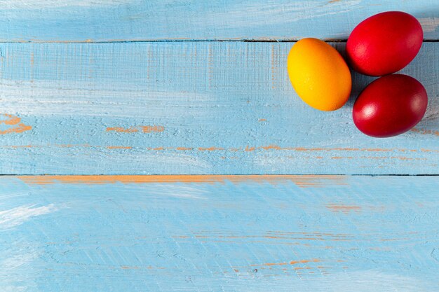 Coloridos huevos de Pascua en madera azul con espacio de copia