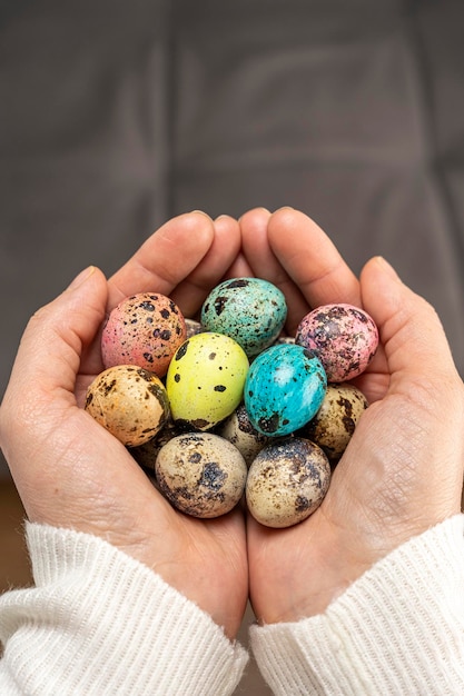 Coloridos huevos de pascua en manos de mujeres huevos de codorniz