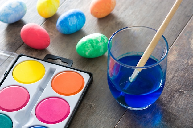 Coloridos huevos de Pascua en mesa de madera