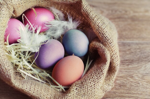 Coloridos huevos de Pascua en mesa de madera.