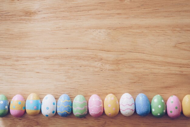 Coloridos huevos de pascua en mesa de madera
