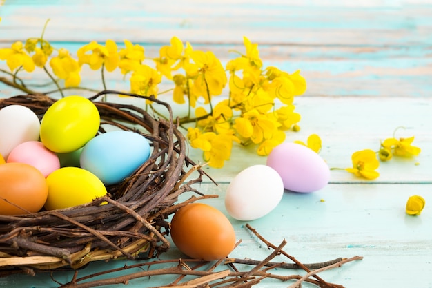 Coloridos huevos de Pascua en el nido con flores. Vacaciones en la temporada de primavera. tono de color de la vendimia