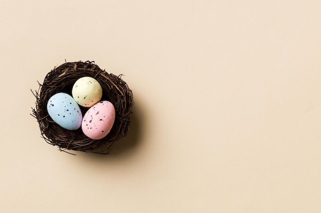 Coloridos huevos de pascua en el nido en el fondo de la mesa con vista superior del espacio de copia