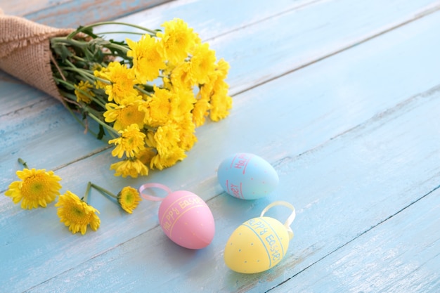 Coloridos huevos de Pascua con ramo de crisantemo amarillo