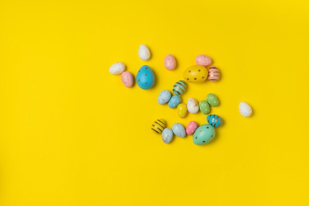 Coloridos huevos de Pascua sobre fondo amarillo Vista superior de huevos festivos