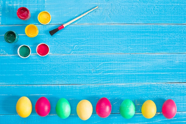 Coloridos huevos de Pascua sobre fondo de madera rústica azul