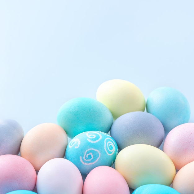 Coloridos huevos de Pascua teñidos con agua coloreada aislados en un concepto de diseño de fondo azul pálido de la actividad de las vacaciones de Pascua cerca del espacio de copia