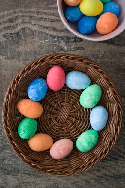 Coloridos huevos de Pascua tradicionales en un tazón de madera