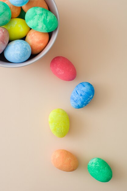 Coloridos huevos de Pascua tradicionales en un tazón en una vista superior marrón