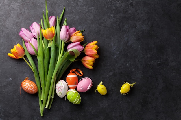 Coloridos huevos de Pascua y tulipanes