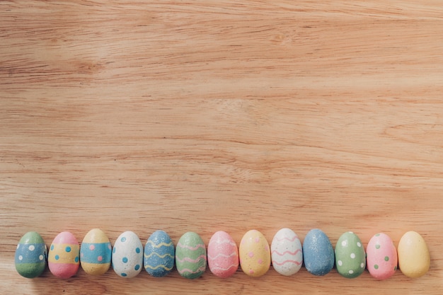 Coloridos huevos de Pascua en vintage de fondo de mesa de madera con espacio de copia.