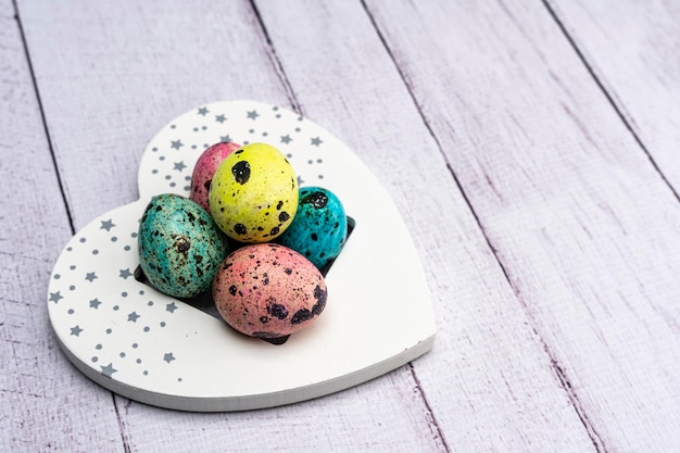 Los coloridos huevos de Pascua yacen en un corazón decorativo