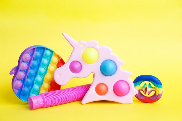 Coloridos juguetes antiestrés sensoriales fidget sobre un fondo amarillo