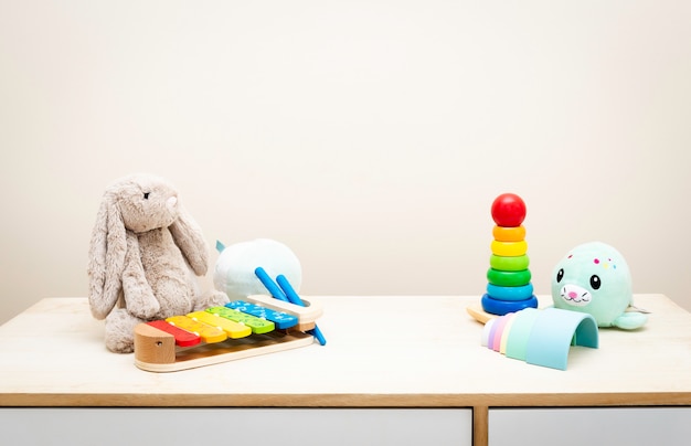 de coloridos juguetes infantiles contra la pared Juguetes en mesa de madera con copyspace