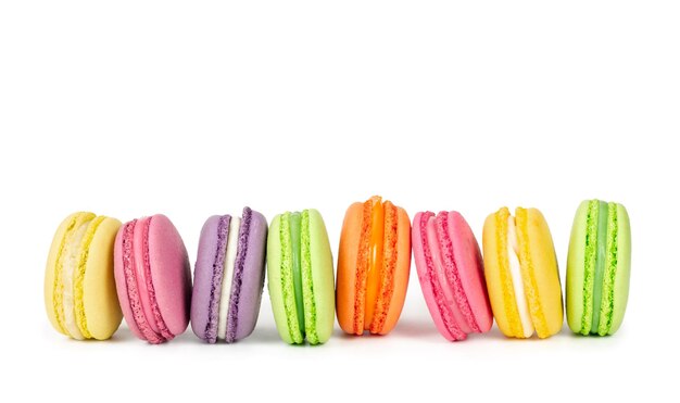 Coloridos macarons franceses en fila aislado sobre fondo blanco.