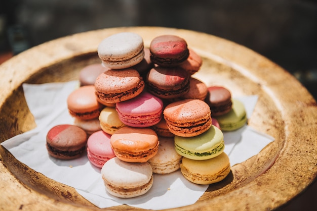 Coloridos macarons franceses o macarons en una placa dorada