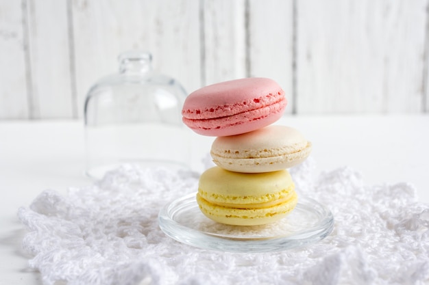 Coloridos macarons franceses sobre una madera blanca