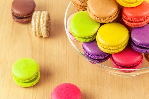 Coloridos macarons franceses en un soporte de pastel de vidrio