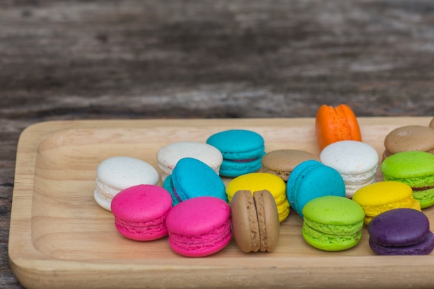 Coloridos macarrones en plato sobre mesa de madera