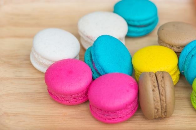 Coloridos macarrones en plato sobre mesa de madera