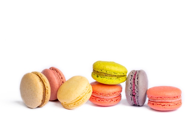 Foto coloridos pasteles de macarrones pequeños muffins franceses coloridos macarons sobre un fondo blanco