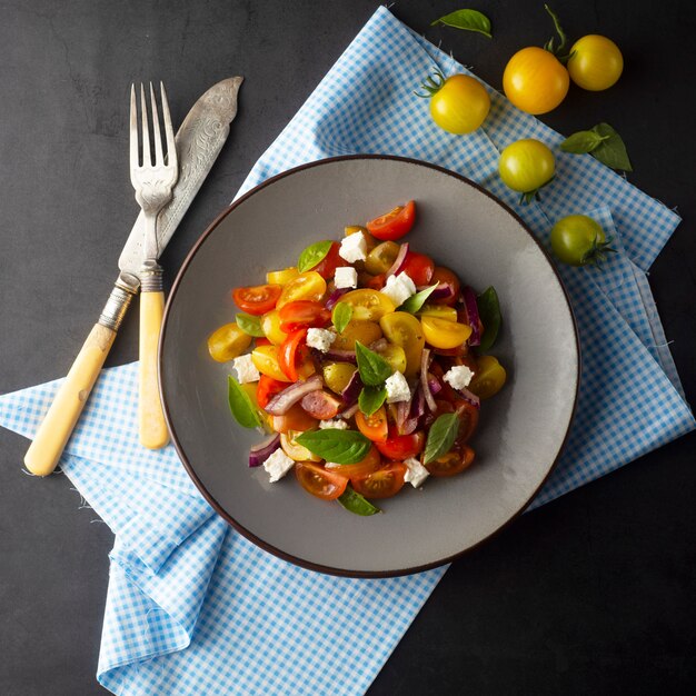 Coloridos tomates y albahaca ensalada en un plato. Comida saludable de verano.