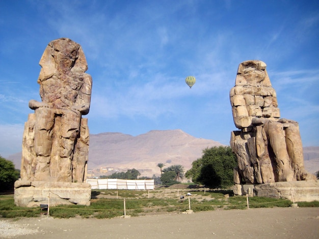 Colosos de Memnon con globo en el cielo Valle de los Reyes Luxor Egipto