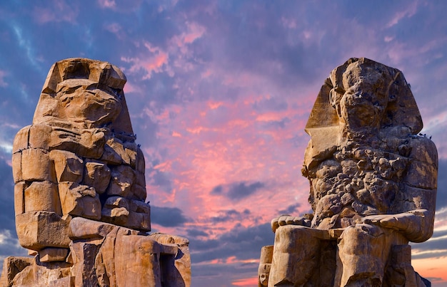 Colossos de memnon luxor tebas contra o pano de fundo do amanhecer no egito