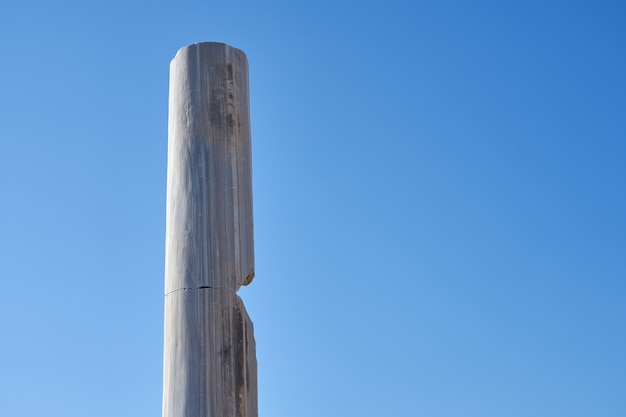 Columna de piedra antigua contra un cielo azul claro.