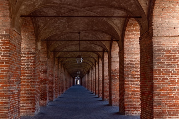 Columnas y arcos de ladrillo rojo en la Galleria degli Antichi en la ciudad de Sabbioneta, Lombardía, Italia