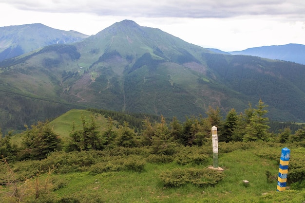 Columnas fronterizas de la frontera rumana-ucraniana en las montañas Concepto de viajes de senderismo al aire libre Cárpatos Ucrania